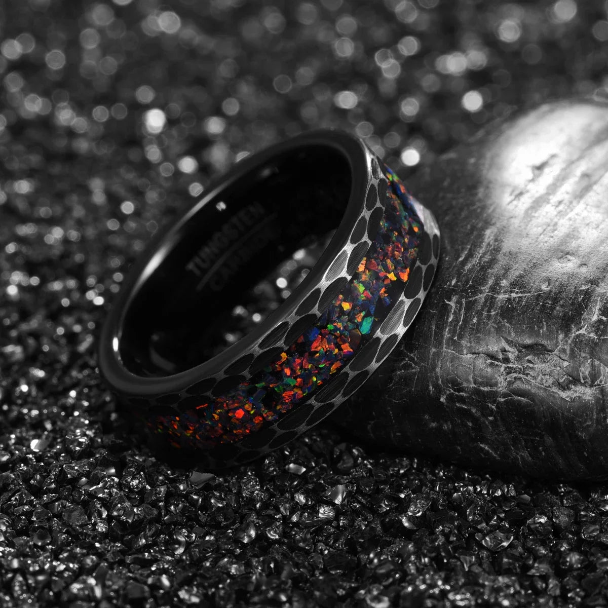 Black ring with multicolored interior on a textured surface